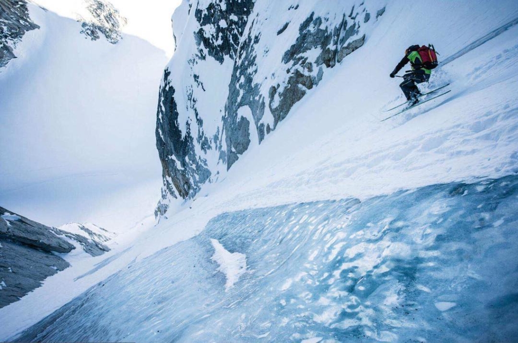 A skier skies down a very icy steep chute
