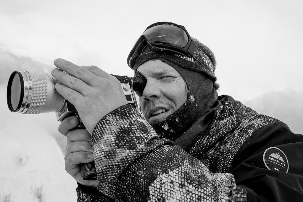 Snowboarder Travis Rice looks through a camera lens