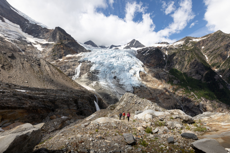 Hiking photographers in a vast glacial mountain landscape