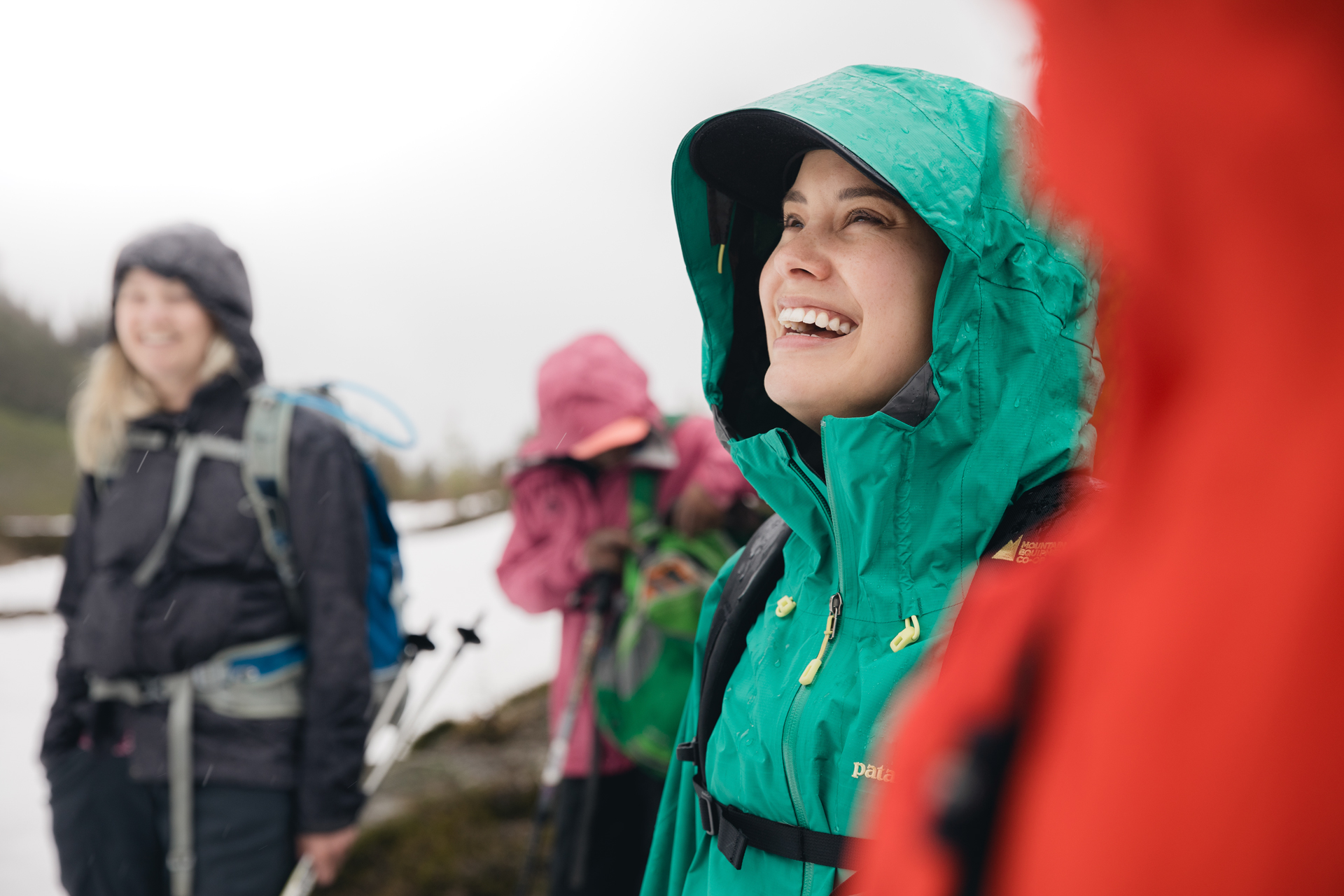 A young woman smiling, surrounded by fellow hikers. 