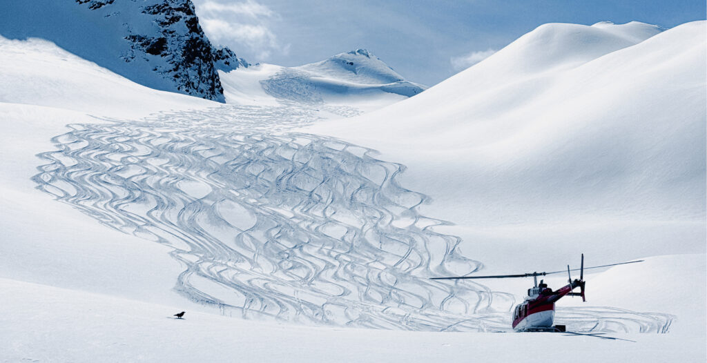A helicopter parked at the bottom of a heli-skiing slope demonstrates that you don't jump out of the helicopter when it's in the air. 
